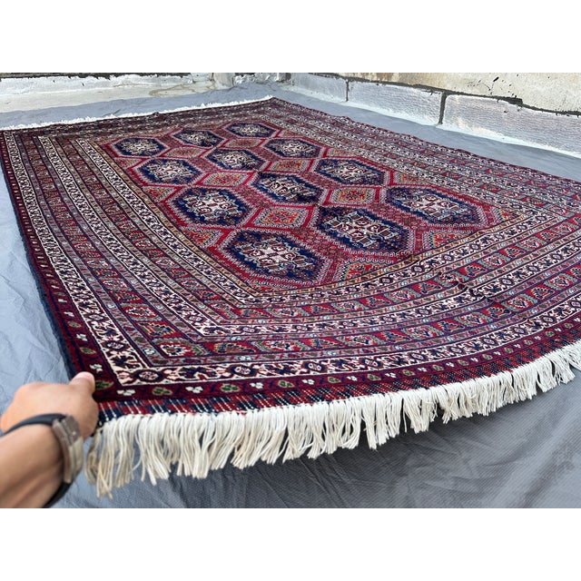 This bold Ersari rug features a striking grid of large octagonal gul medallions in deep navy, each densely patterned with...