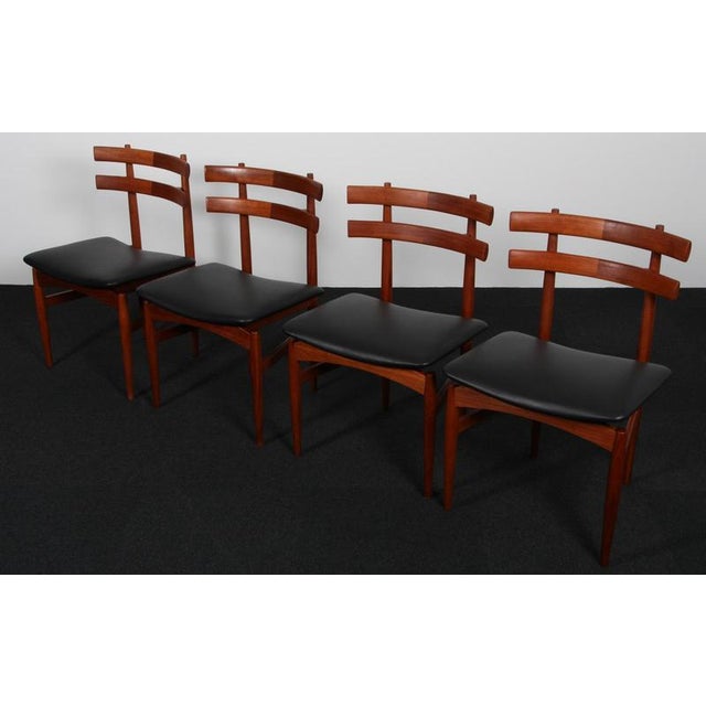 Poul Hundevad set of four dining chairs in teak. New upholstered with black aniline leather. Made and designed by Poul...