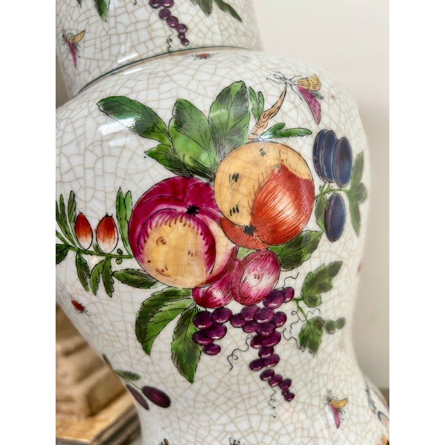 A striking vintage porcelain vase by United Wilson, beautifully decorated with colorful fruit, foliage, butterflies and...