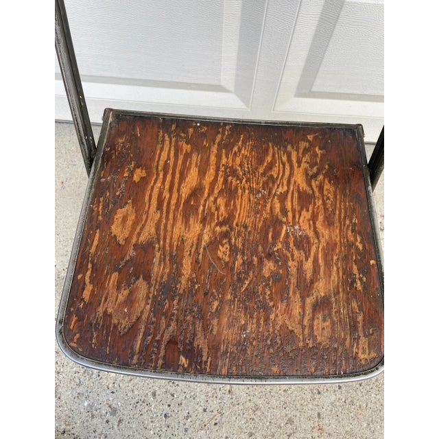 Unique 1950s industrial metal folding chair with wood grain seat. Beautiful wood patina on the seat. Weathering and...