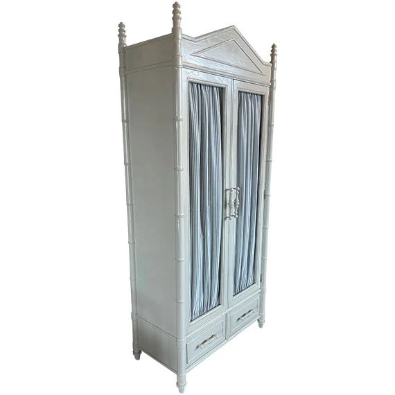 This piece is a Hollywood Regency–inspired armoire with strong faux bamboo and Palm Beach coastal influences.