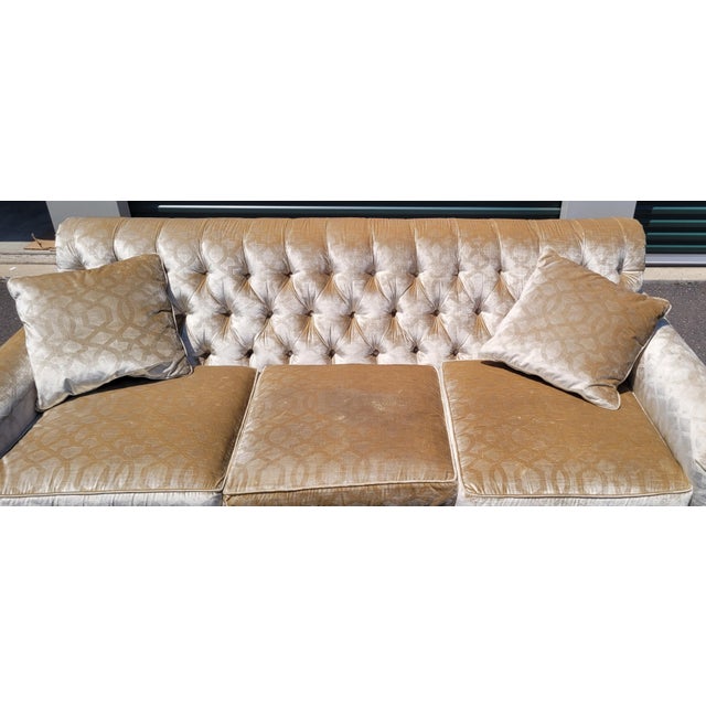 A super fine Theodore Alexander long rolled arm and tufted sofa. Featuring a fringe skirt over top a pleated skirt tufted...