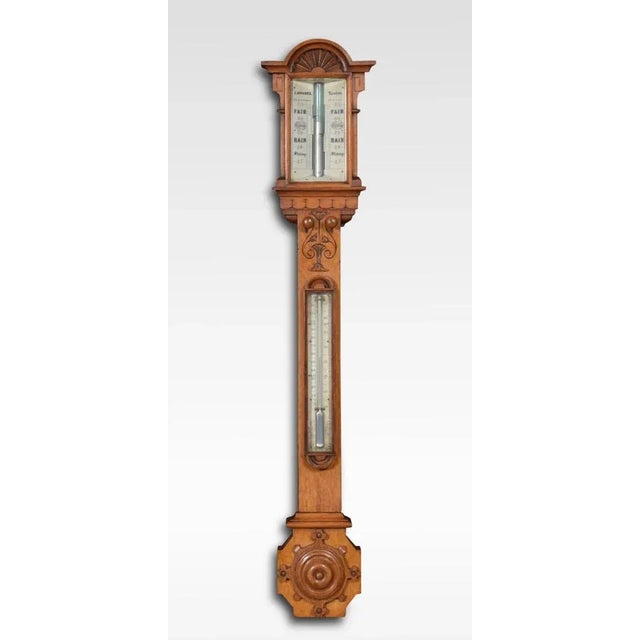 Late 19th-century oak cased stick barometer and thermometer, with engraved scales contained in oak case having shaped and...