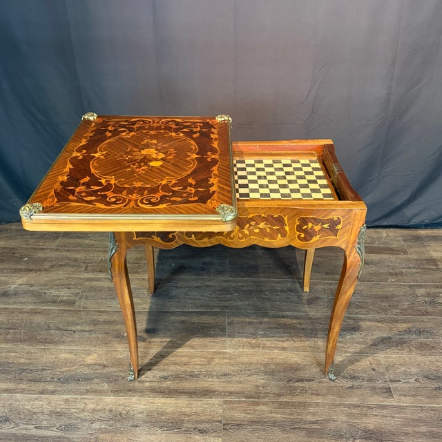 Exceptional French game table, circa 1900, beautifully crafted with a richly figured parquetry top centered by an...