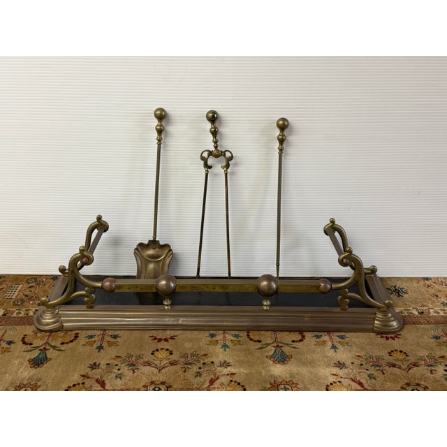 Design Plus Gallery presents a Vintage Brass Fireplace Fender + Three-Piece Tool Set. The long rectangular fender displays...