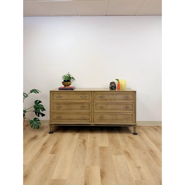 This vintage mid-century modern dresser showcases a striking gray washed, blonde wood finish that offers a lighter, more...