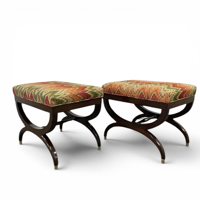 A pair of custom curule benches or ottomans upholstered in a striking fabric. Designed by Scott Arthur Yerkley, they are...