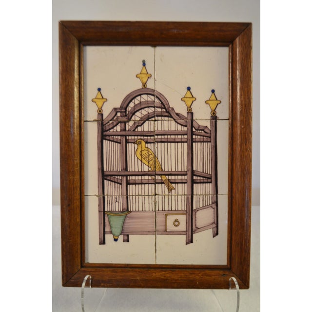 18th century delft tile wall picture of a bird in a cage with a manganese based purple colored cage, a yellow bird, yellow...