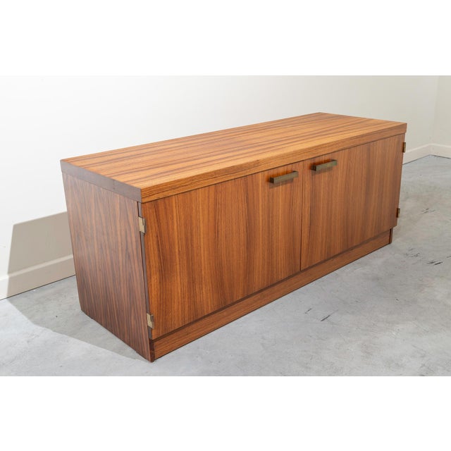 Nordic-style cabinet with two doors and interior shelves, made of sycamore wood. Brass handles and hinges.