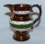 Beautiful little copper lustreware creamer with green band around body and three white bands decorated with pink lustre vines