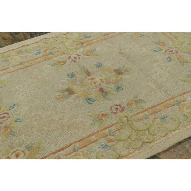 This antique 4x6 hooked rug, circa 1920–1929, features delicate floral medallions and garland borders rendered in soft...