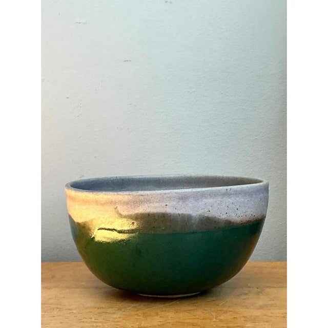 This vintage studio pottery bowl has a deep, rounded, hemispherical form that rises from a small, slightly recessed foot...