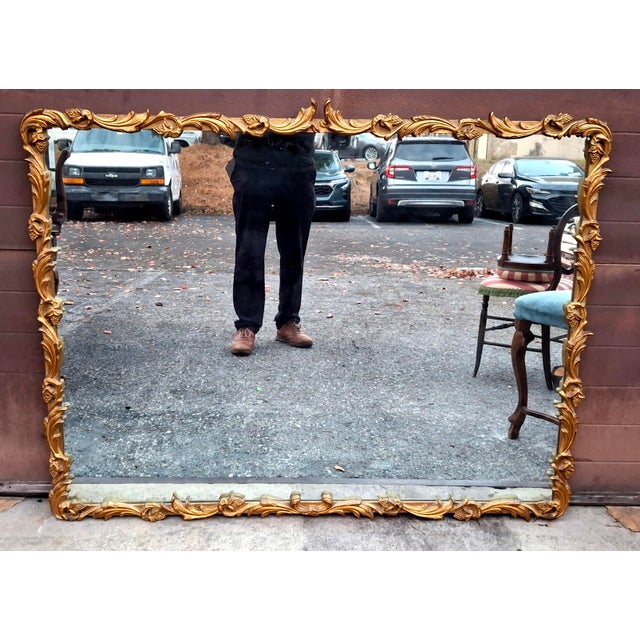 A Large Louis XIV Style Carved Gilt Wood Foliate Frame Wall Mirror, Circa 1920s Approxim dimensions: 51" in width, 38.5...
