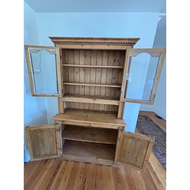 A handsome antique English pine hutch with beautifully aged warm wood tones, classic proportions, and the character and...