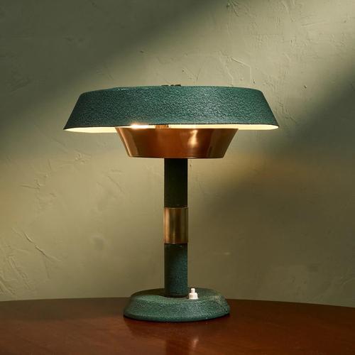 This table lamp, crafted by an Italian manufacturer during the 1950's, showcases a harmonious blend of industrial design...