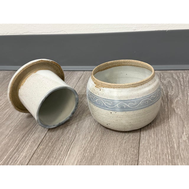 This charming mid-century butter crock was hand-thrown in 1955, showcasing the quiet elegance of studio pottery from the...