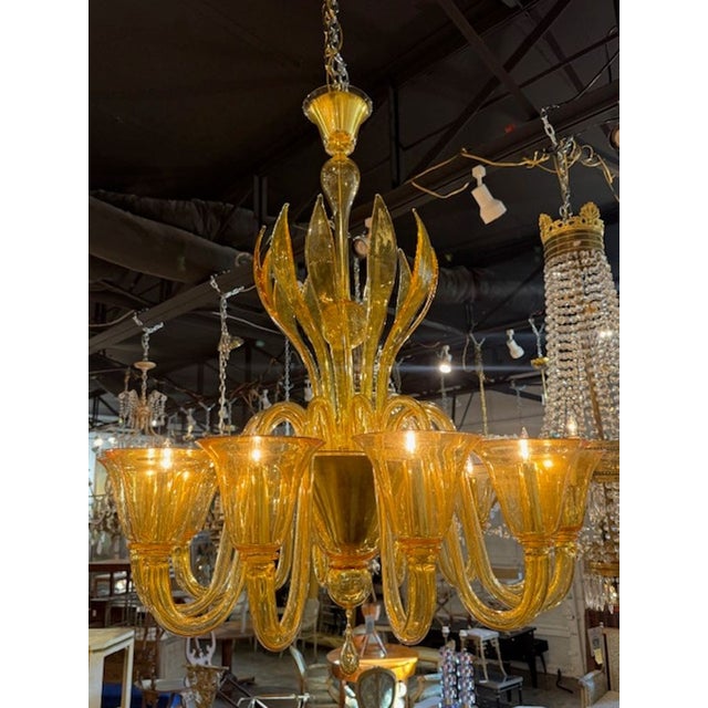 This vintage amber colored Murano glass chandelier with 12 arms. The chandelier is made of beautiful colored glass...
