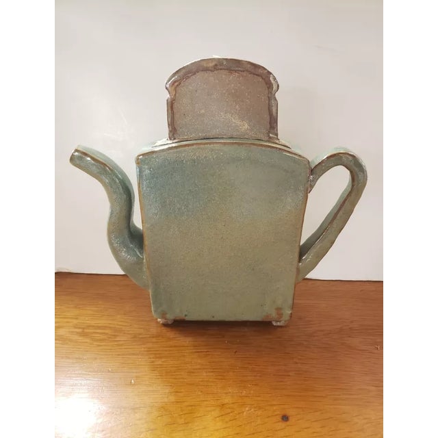 This is a Heavy Green Glazed Art Pottery Teapot Shaped Toaster with Slice of Toast Lid. It measures 11 1/4" high with lid,...