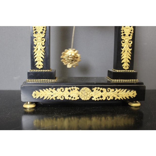 Pens portico of the era restore in black marble and gilded bronze, decor of palmettes and cuts, gilded dial, native...