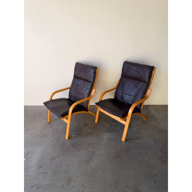 Elegant pair of vintage Danish lounge chairs by Stouby, made in Denmark and upholstered in original dark leather. These...