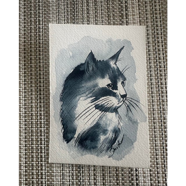 A striking side-profile portrait of a cat rendered in layered watercolor washes. Bold contrast and expressive linework...
