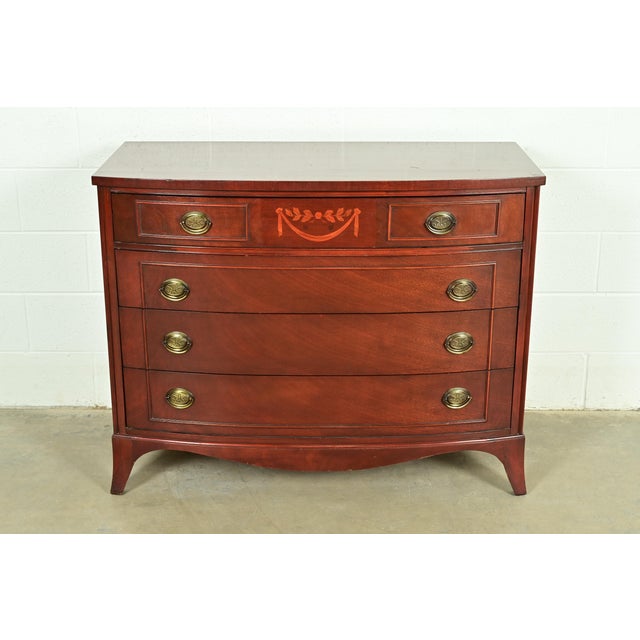 A gorgeous Federal or Hepplewhite style bow front four-drawer dresser or chest of drawers By National Furniture Co. of...