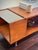 A MCM architectural 1960s mid-century modern coffee table crafted in warm teak veneer and wood. The raised central wood...