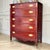 This vintage Federal-style mahogany tall chest features elegant neoclassical details including reeded corner columns,...