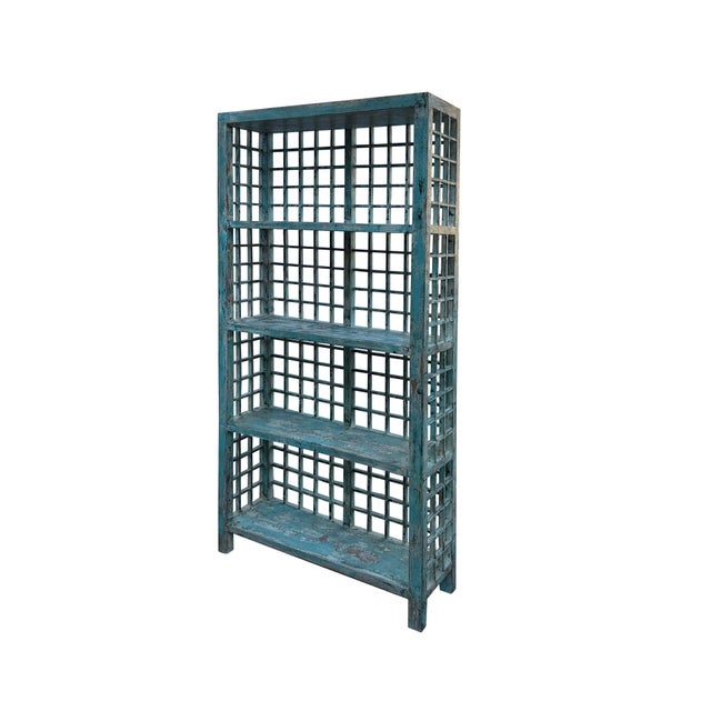 This image showcases a tall, narrow shelving unit with a rustic, industrial aesthetic, constructed from wood and painted...