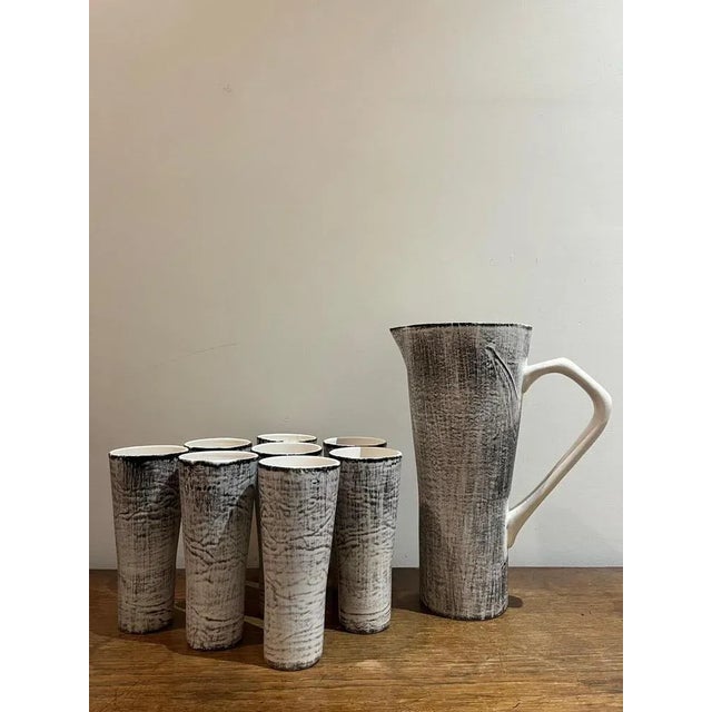 A pitcher and 8 goblets (a chip photographed) . Pitcher L 23 prof. 14 h 30,5 cm Glasses Diameter 7,5 h 17,2 cm