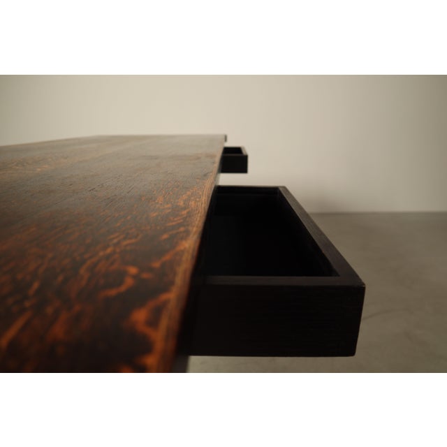 A substantial dining table designed by jean batenburg for mi, belgium, circa 1969. executed in dark-stained oak, the table...