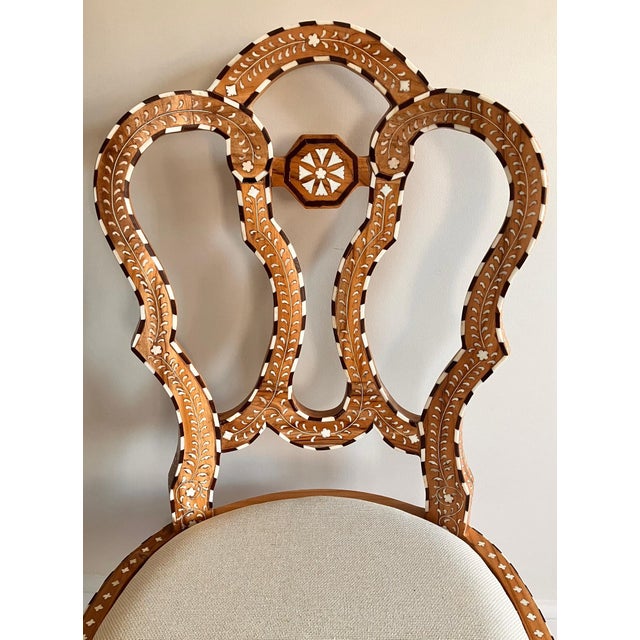 This Anglo Indian dining chair has a beautiful natural wood finish with an upholstered seat. This chair is made from...