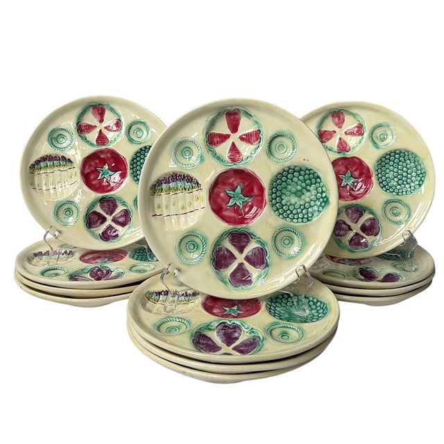 This is a charming set of twelve vintage French majolica plates by Portieux Vallerysthal, circa 1930s–1950s. Each cream-...