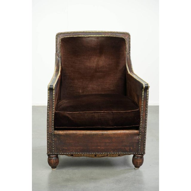 This distinctive antique Art Deco armchair is crafted from a combination of cowhide and velour. The armchair features coil...