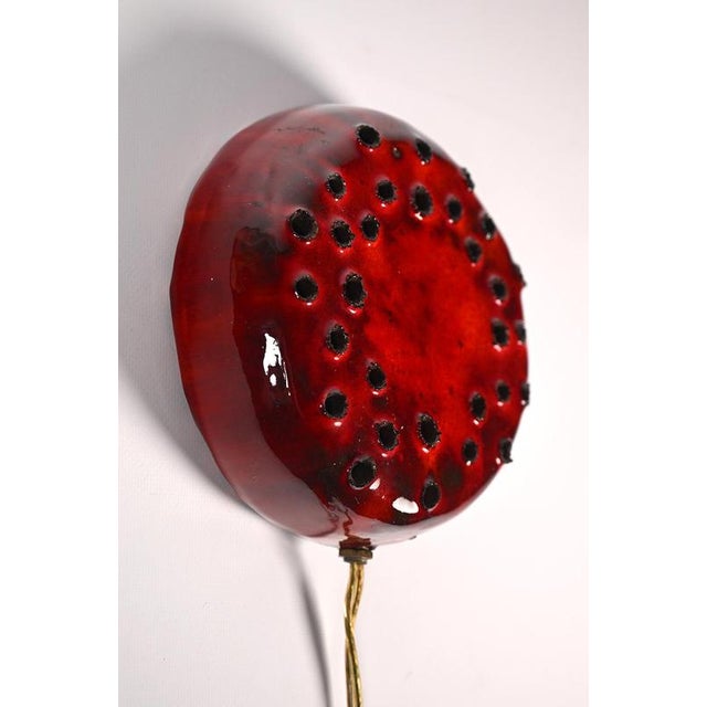 Danish ceramic wall sconce. A very decorative piece this small lamp made of dark clay and glazed in bright red. The light...