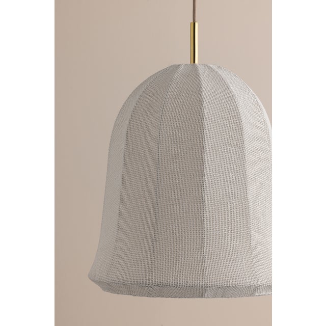 The Risa pendant nods to Neoclassical motifs with its sweeping arches and flutes, yet its materiality is rooted in the...