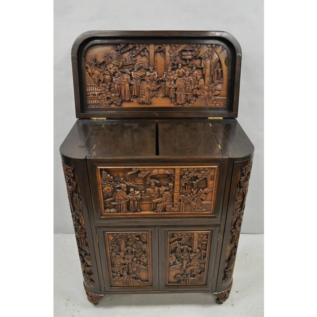 Vintage J. L George Zee Style Chinese Figural Carved Teak Wood Flip Top Dry Bar Cabinet. Item features multiple doors and...