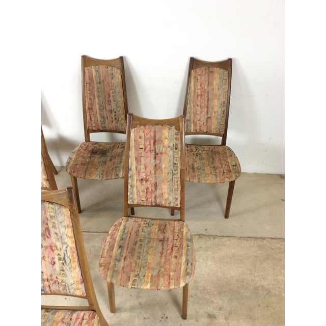 This set of six mid century modern dining chairs features hardwood construction, original walnut finish, six identical...