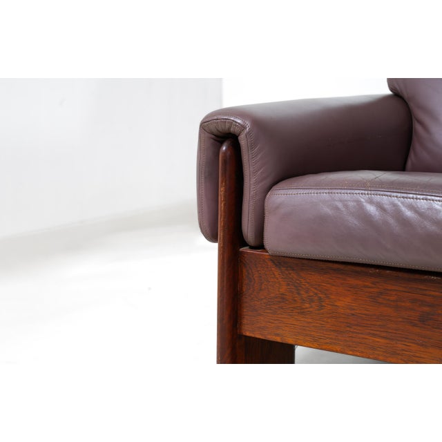 A generous four-seater in stunning wood and mauve leather. The solid frame rests on sculpted side panels with cut-out...