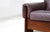 A generous four-seater in stunning wood and mauve leather. The solid frame rests on sculpted side panels with cut-out...