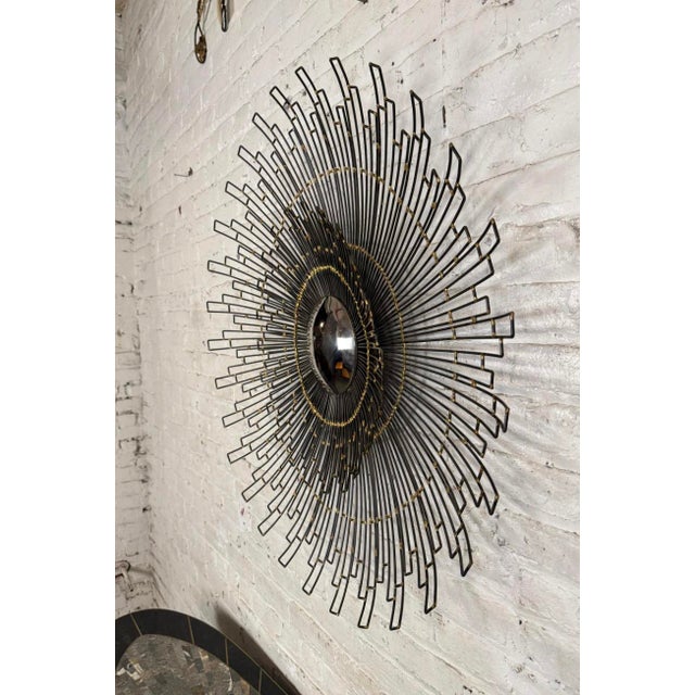 This vintage wall mirror features a geometric sunburst pattern making for a distinctive addition to the modern interior....