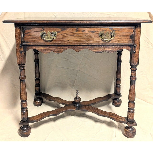 This antique solid oak table appears to be a late 19th or early 20th century (1880-1910) revival side or tavern table, in...