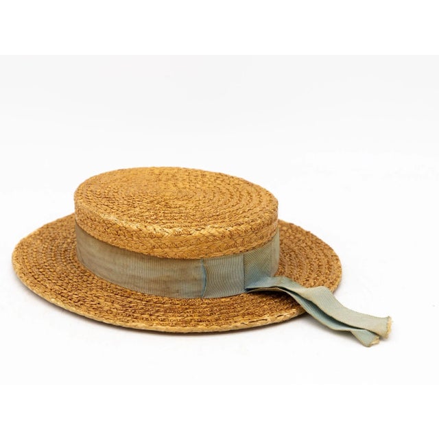 The Ridgemont Make's vintage 1930s boater hat showcases timeless elegance with its natural straw construction. Adorned...