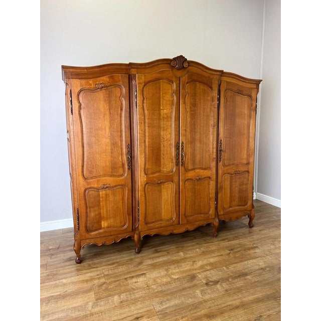 An elegant Vintage French Louis wardrobe in Oak , featuring four beautifully shaped panelled doors, a sweeping curved top...
