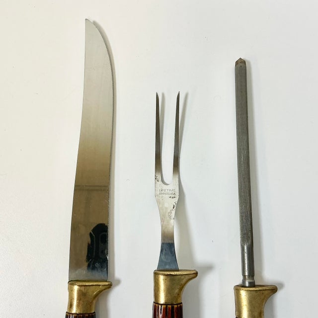 This vintage Cutlery Set is from the 1950s. It features a Carving Knife, Fork and Sharpener. The blades are stainless...