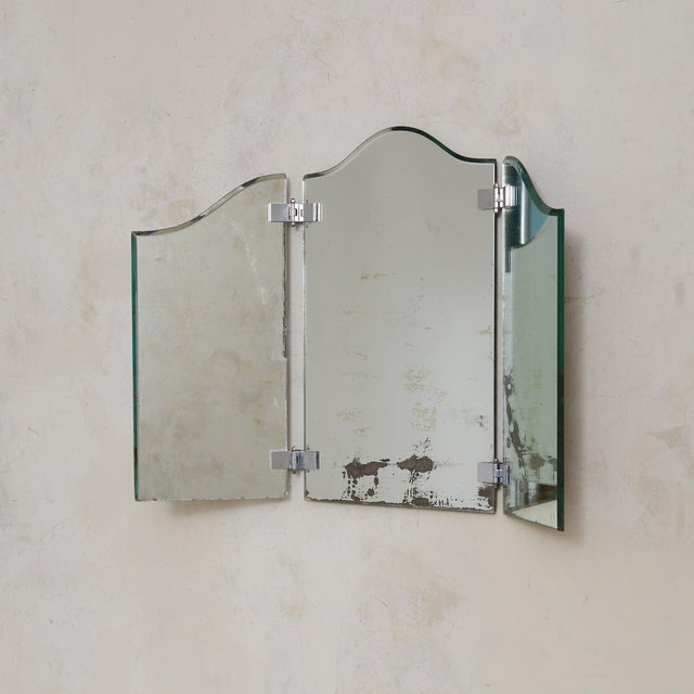 A French Art Deco triptych vanity mirror, dating back to the 1930s. Each beveled pane curves in a soft crest along the top...