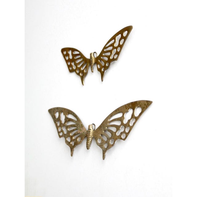 A pair of vintage mid-century brass butterfly wall hangings in two graduated sizes. Each sculptural butterfly features...