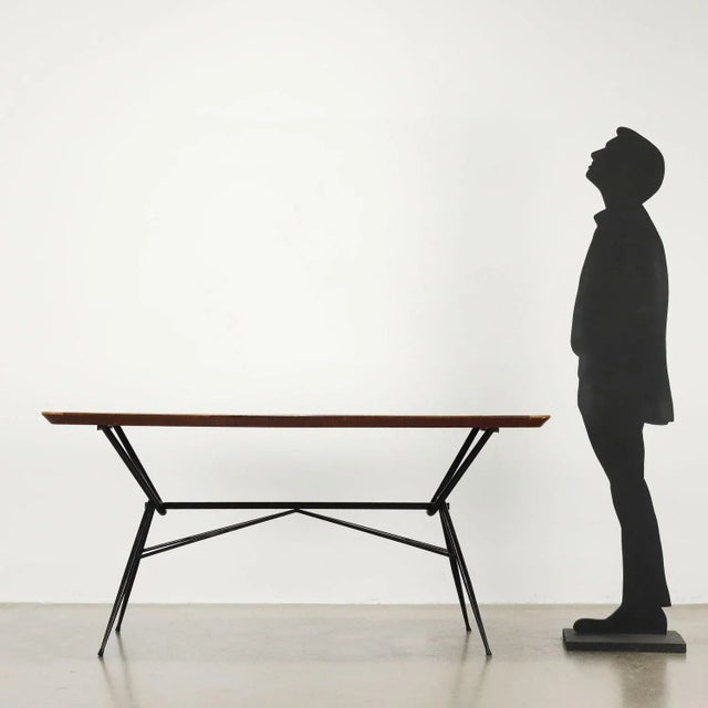 Dining table made in Italy with black lacquered metal structure, wooden top with back-treated glass. This piece is...