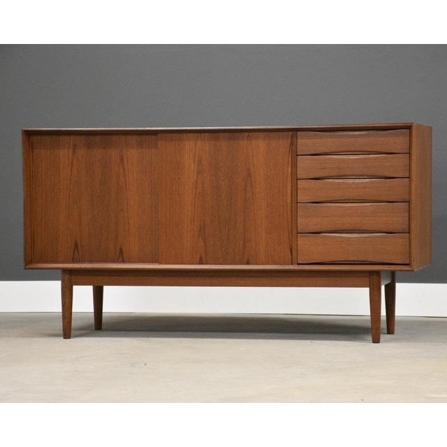 A mid century modern teak credenza with two sliding doors and five drawers. Beautiful Danish design similar to those of...