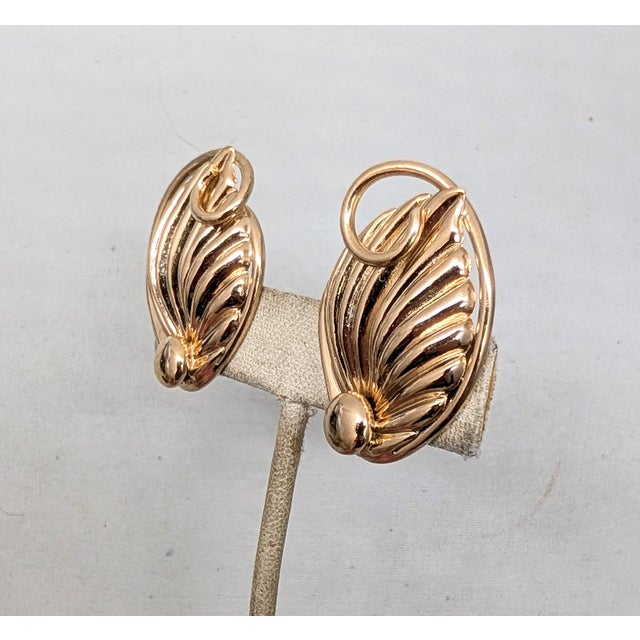 1950s goldtone ribbed raised leaf with curled stem and round raised circle at the bottom clip earrings. Marked "NAPIER...